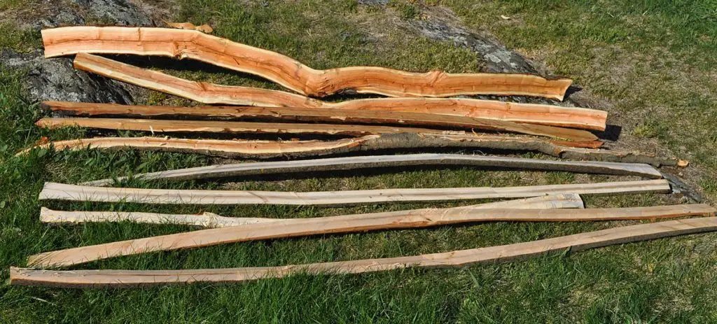 High quality timber planks and a handcrafted recurve bow displayed on a workbench.