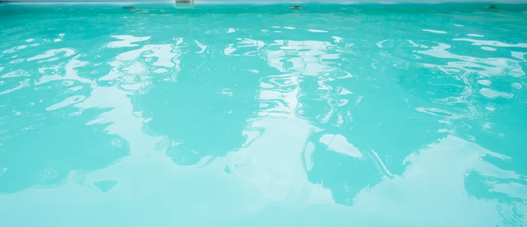 Homeowner holds a water testing kit beside a cloudy above-ground backyard pool.