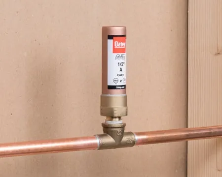 A large multi-fixture water hammer arrestor installed on a main water supply branch.