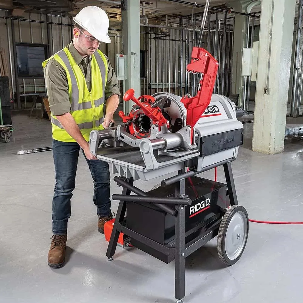A large stationary pipe threading machine mounted on a heavy workbench in a workshop.