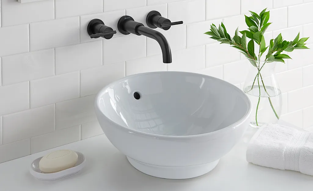 Measuring the distance between vanity holes to choose the right bathroom faucet.