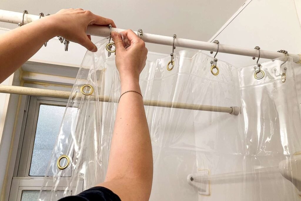 A modern bathroom interior featuring a clean and translucent shower curtain liner.