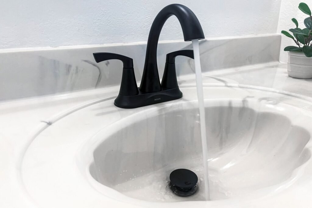 A modern chrome faucet on a marble vanity representing the best bathroom faucets.
