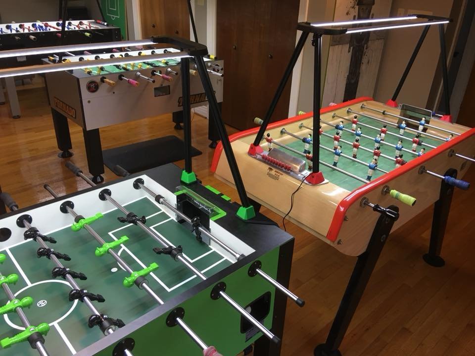 Modern foosball table with bright LED lights in a game room