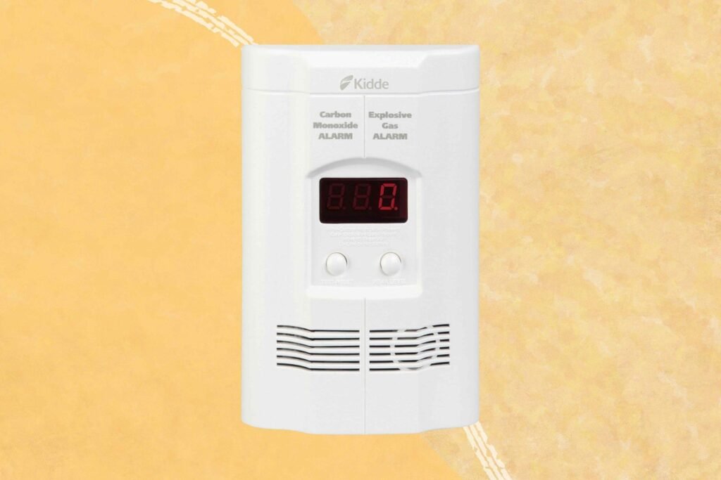 A modern gas leak detector mounted on a clean kitchen wall for home safety.