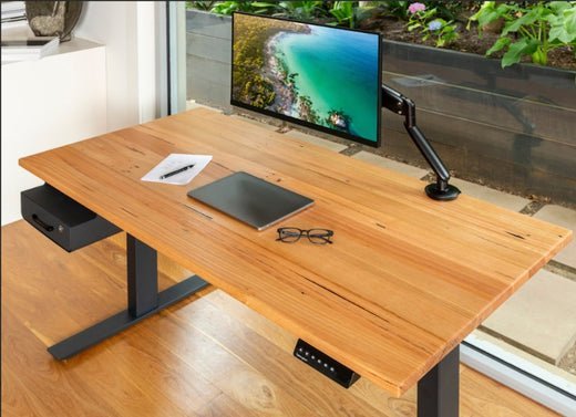 A modern home office featuring a beautiful solid wood desk bathed in natural light.