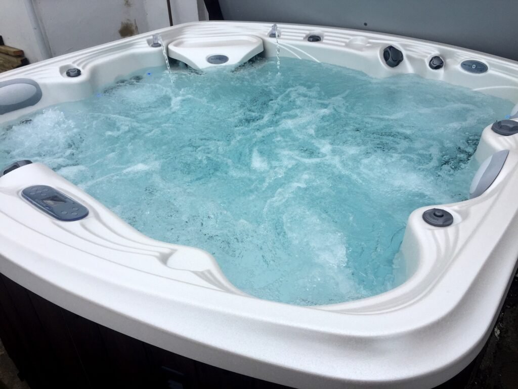 Modern hot tub with steam rising and a visible error code on the digital panel.