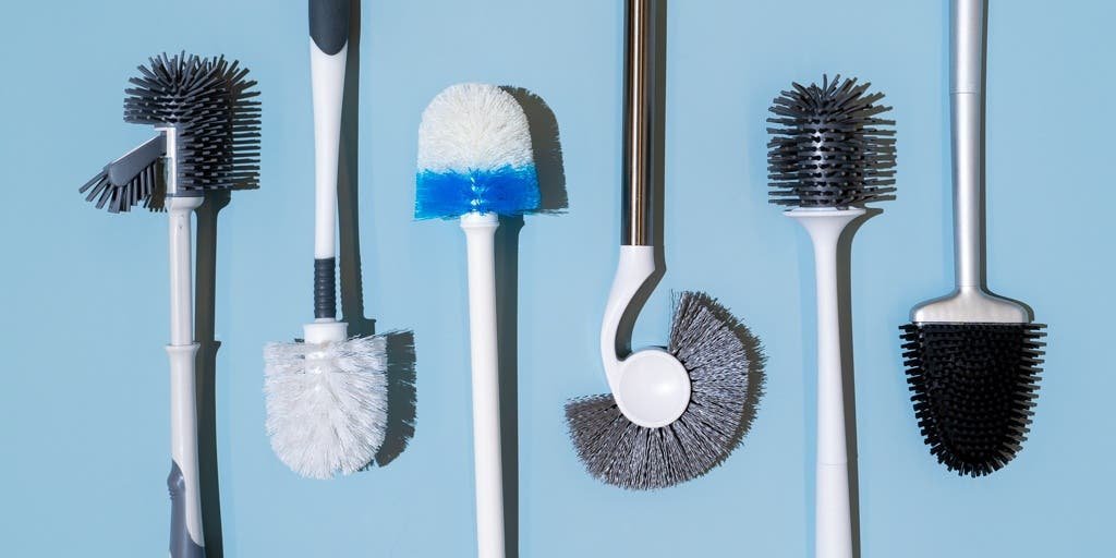 A modern, minimalist bathroom featuring a high-quality toilet brush set for cleaning.