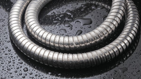 A modern shower hose coiled neatly in a bright, clean, contemporary bathroom setting.