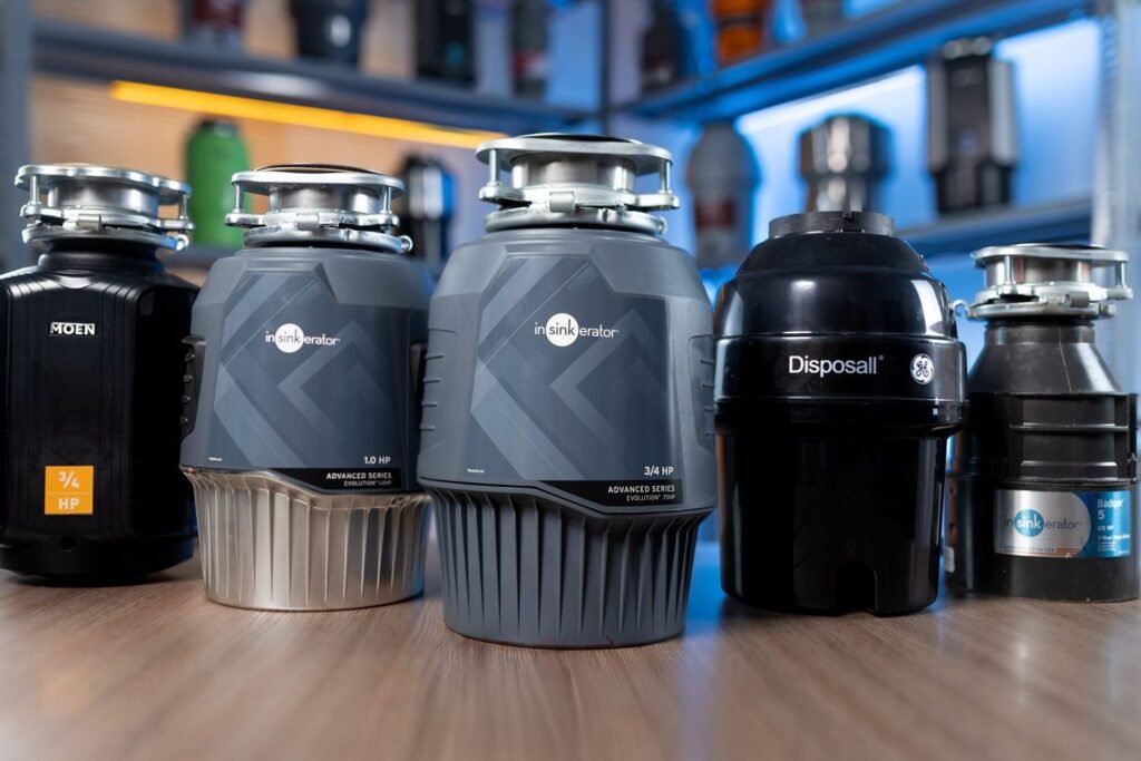 A modern stainless steel garbage disposal unit displayed on a bright marble kitchen countertop.