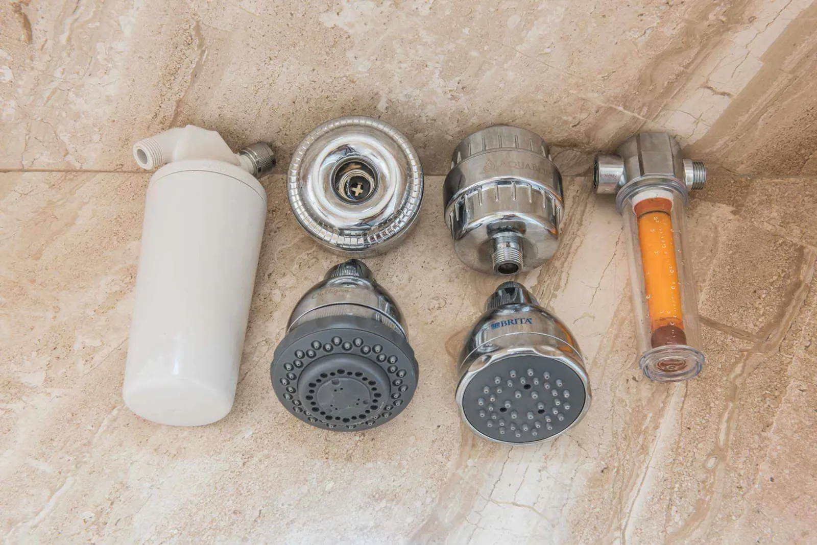 An NSF certified shower head filter sits on a clean marble countertop.
