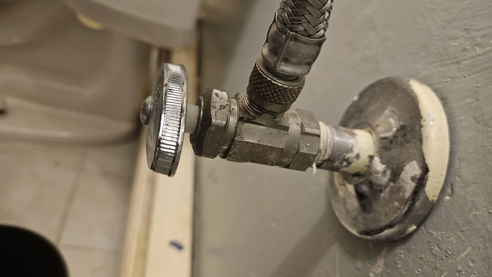 An old gate valve next to a modern ball valve on copper pipes.