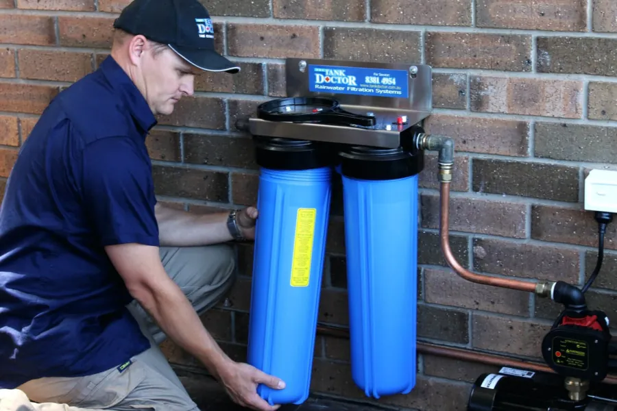 A person reviewing a water quality report next to their whole house water filtration system.