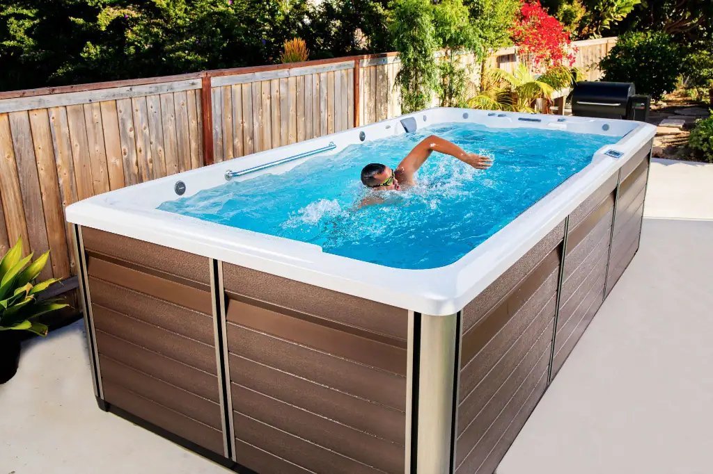 A person swimming in place inside a compact endless pool with a strong current.