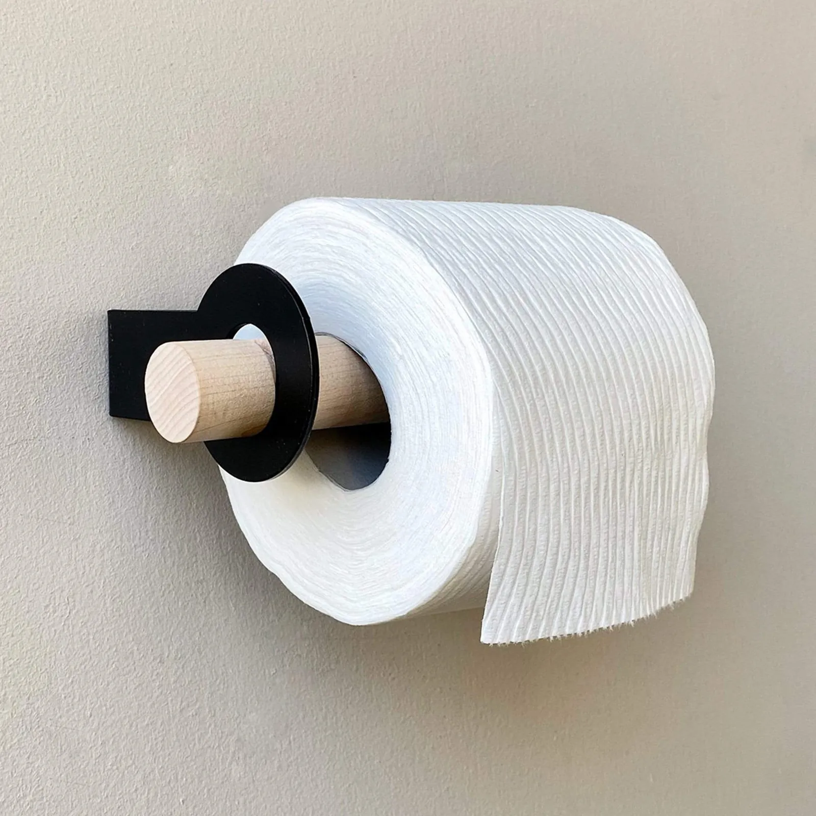 A person using a stud finder to prepare for installing a toilet paper holder.