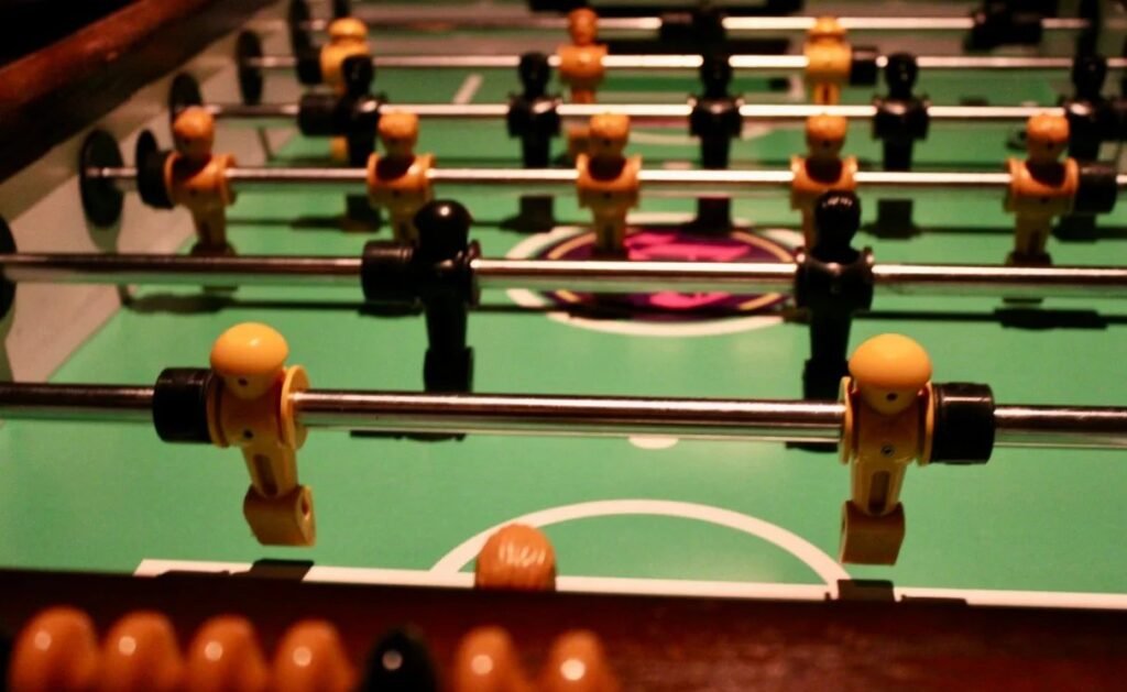 Polished wooden foosball table in bright modern game room