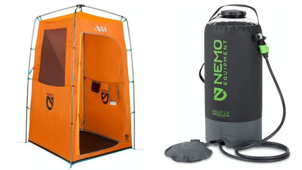A portable shower tent set up in a forest with a solar shower bag dripping water