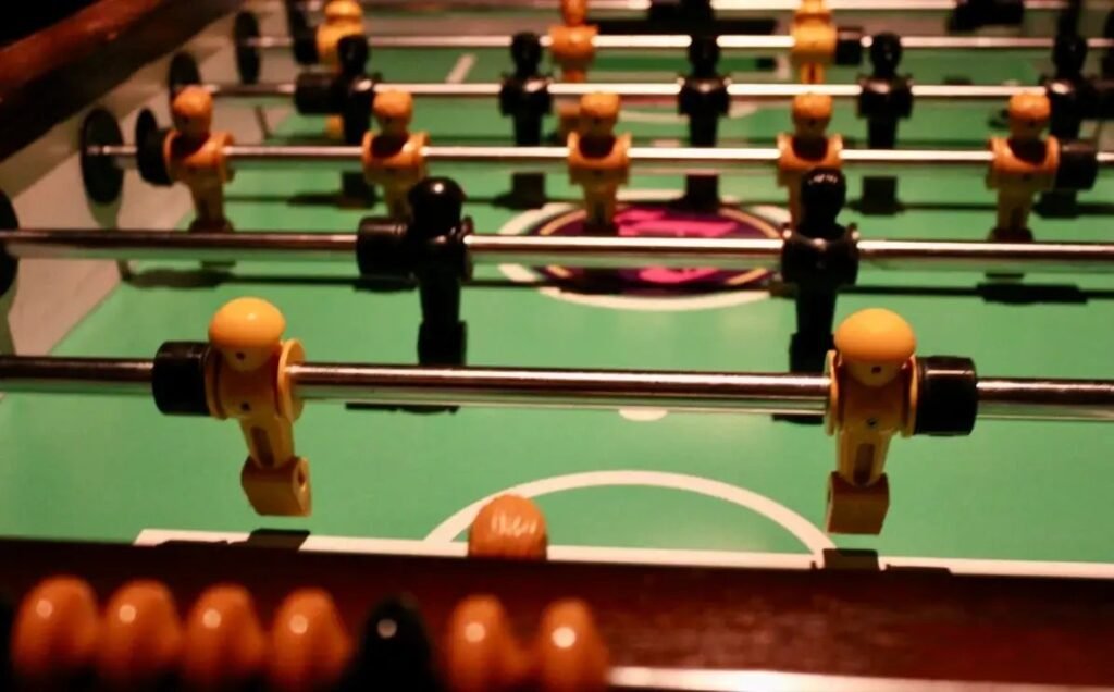 A pristine white foosball table sits in a bright modern living room
