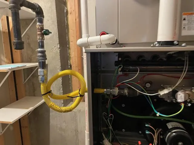 Professional contractor comparing black iron and flexible CSST gas piping methods.