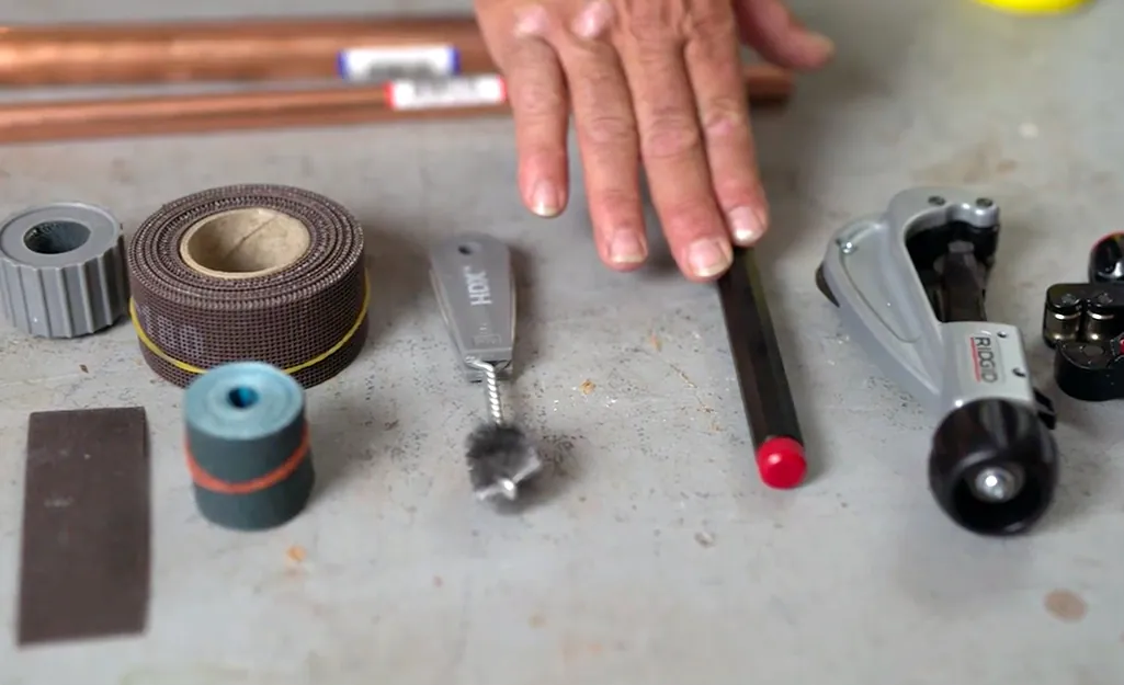 Propane torch and lead-free solder prepared for a safe copper pipe plumbing joint.