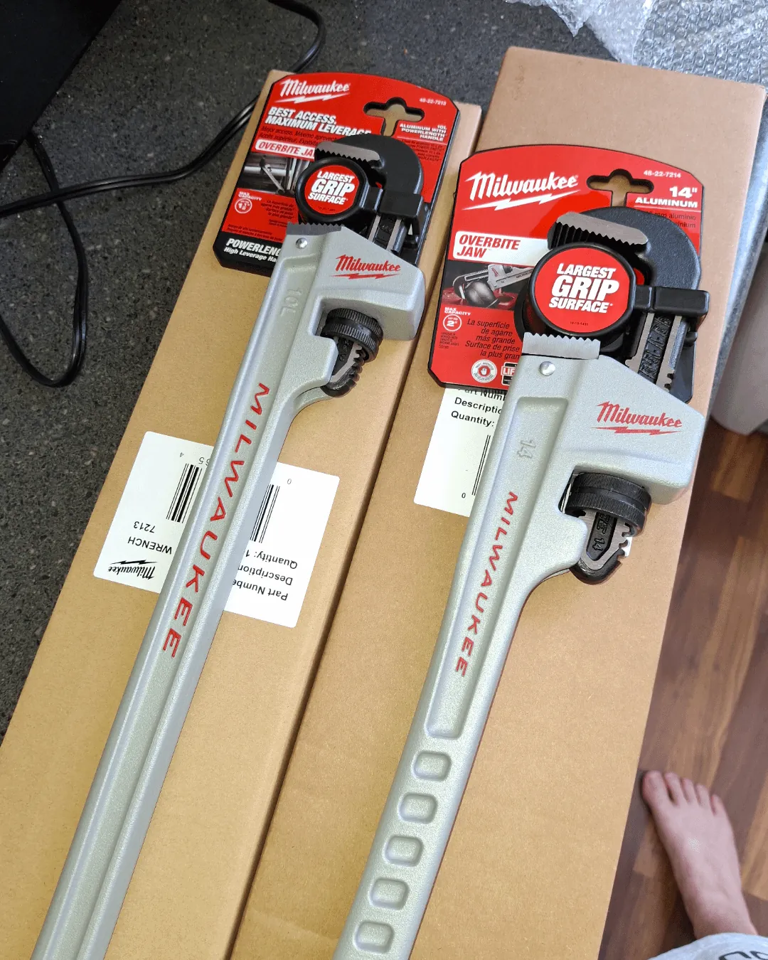 A selection of different pipe wrenches laid out for a plumbing repair job.