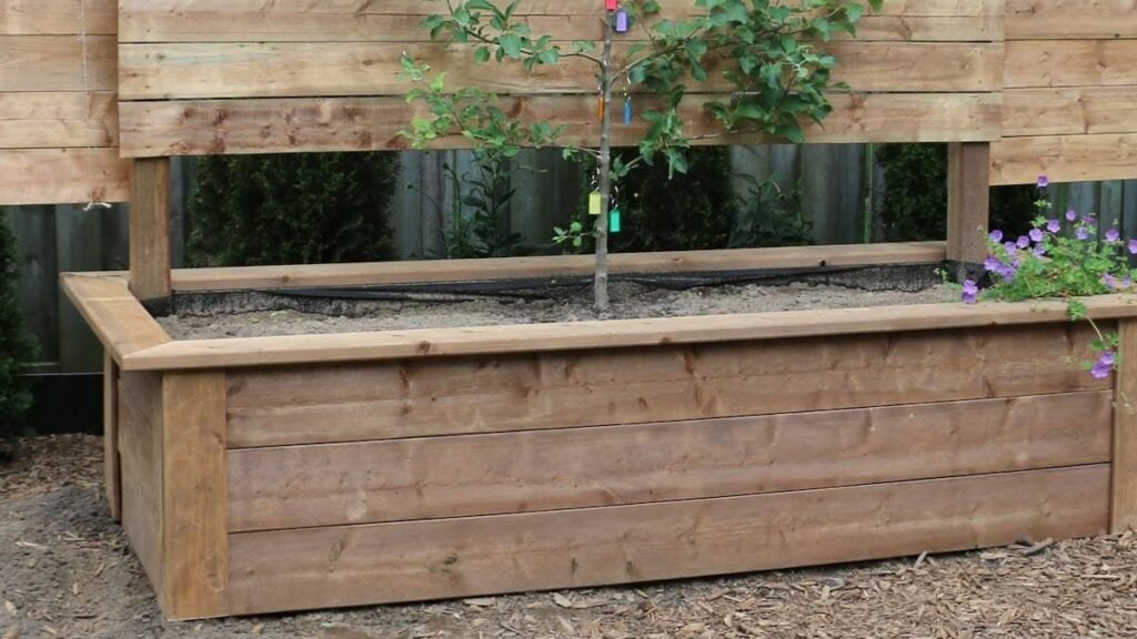 A selection of durable wood planks for building raised garden beds in a sunny garden.