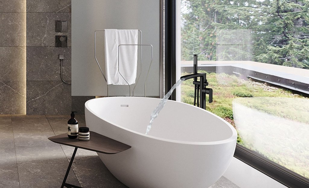 A selection of modern bathroom tub spouts displayed on a marble vanity top.
