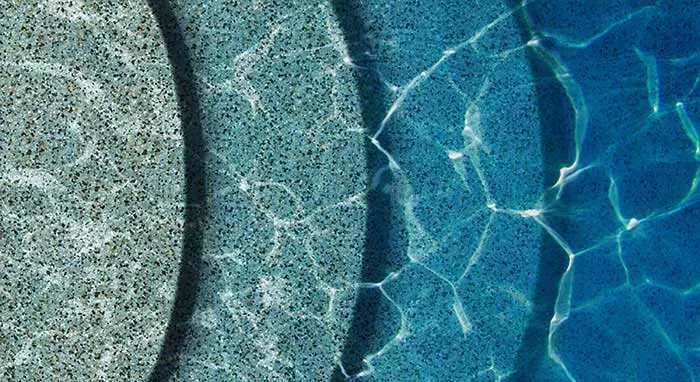 Side-by-side comparison of aqua blue and aqua white mini pebble samples on concrete
