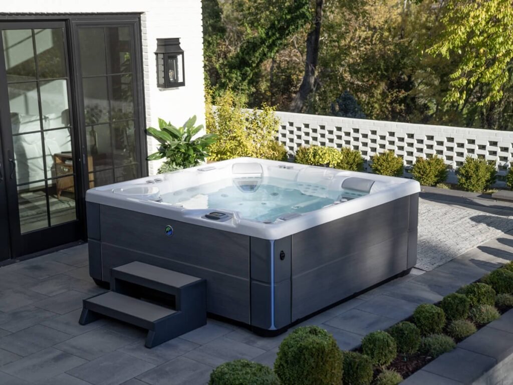 Smartphone showing a hot tub water monitoring app beside a floating water testing device in a modern hot tub