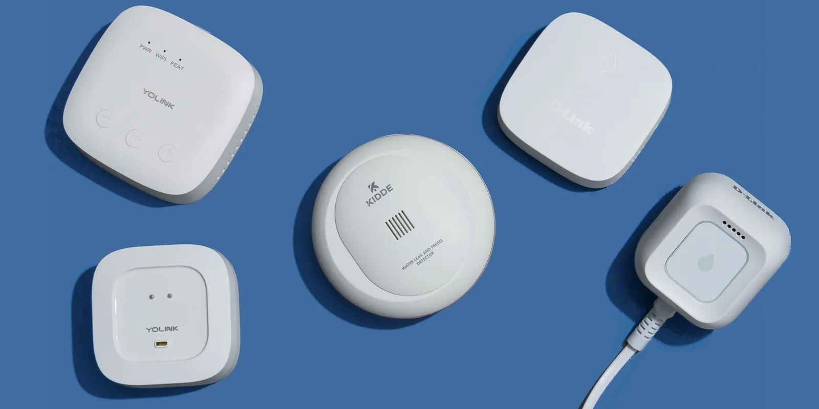A smartphone showing a smart home notification next to a smart speaker on a table.