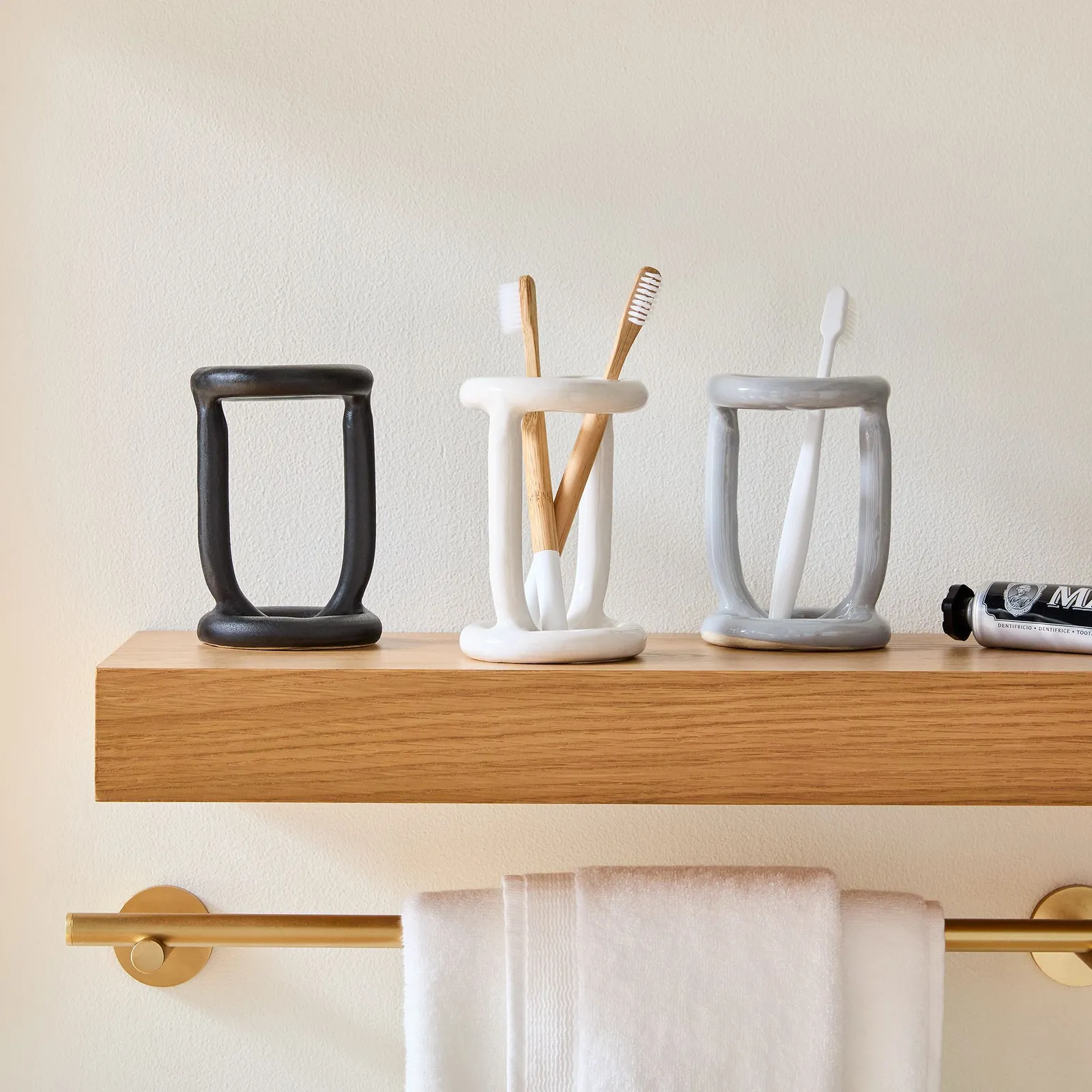 A space-saving silicone toothbrush holder attached to a bathroom mirror with suction cups.
