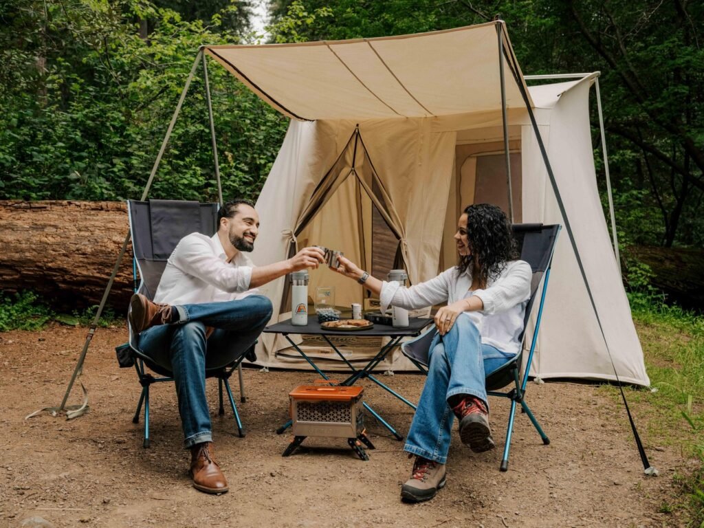 A spacious canvas tent nestled in a forest at dawn, ready for camping.