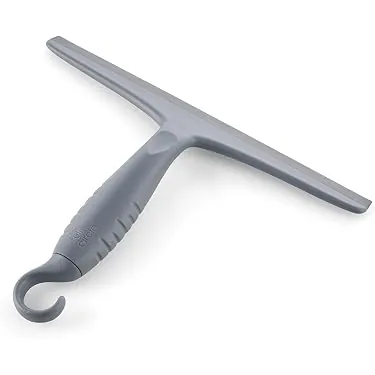 A stainless steel shower squeegee hanging on a suction cup hook on a tiled wall.