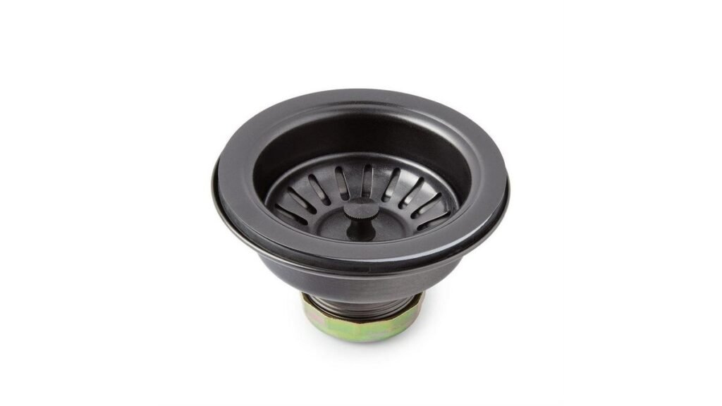 A stainless steel sink strainer and a garbage disposal flange sitting on a granite countertop.