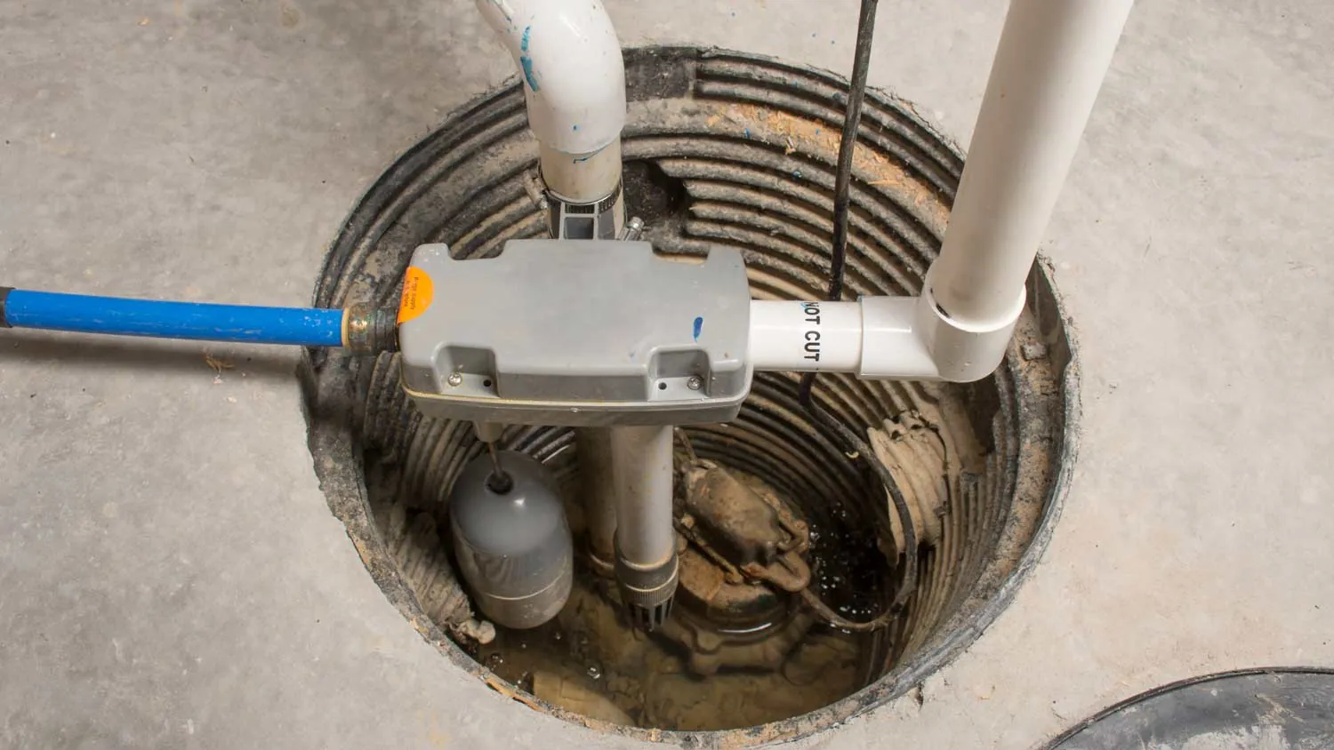 A sump pump installed in a basin for basement flood prevention.