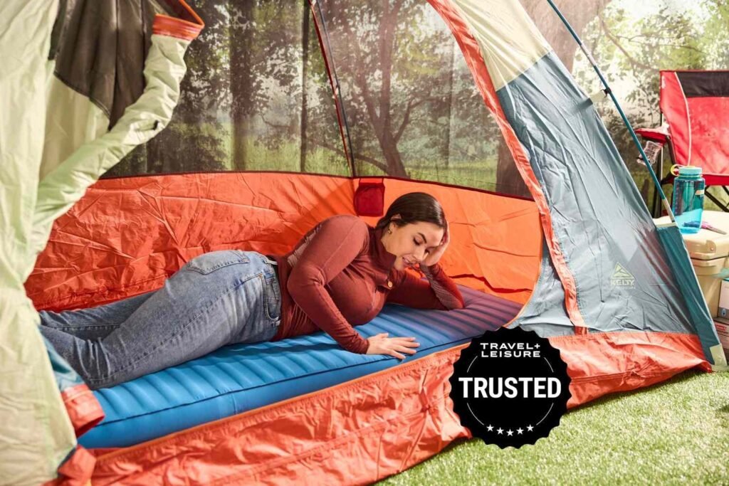 Thick camping air mattress on forest ground with camping gear under soft golden hour light