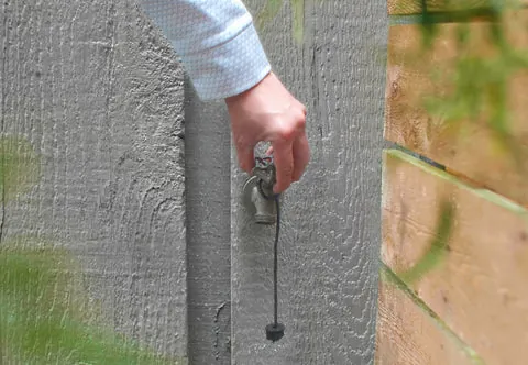 Three distinct types of outdoor faucets arranged on a wooden workbench for comparison.