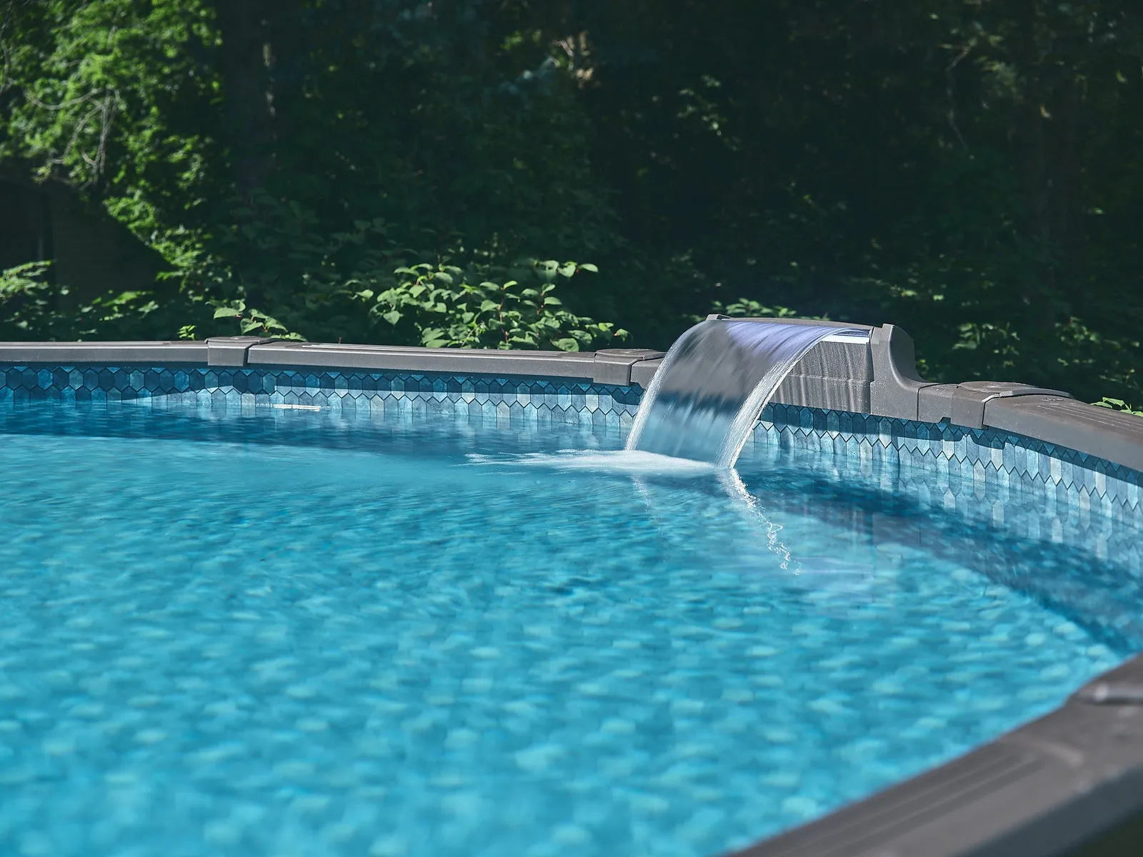 A torn vinyl pool liner shows damage near the submerged pool steps.