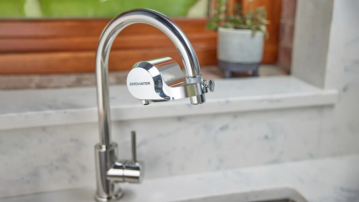 Two different models of faucet mounted water filters displayed on a kitchen counter.