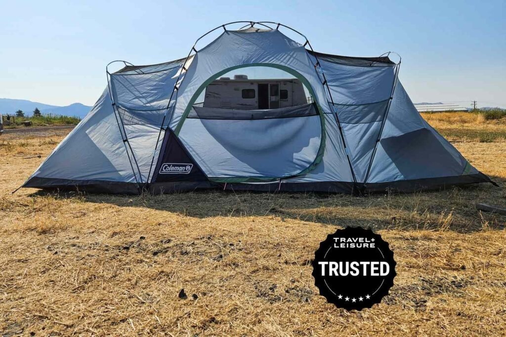 Two-room family camping tent set up in a sunny forest clearing