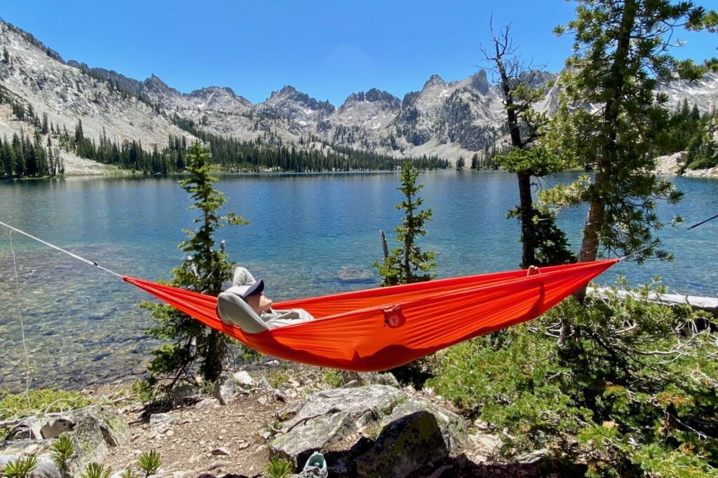 An ultralight hammock pillow placed on a folded hammock in a serene woodland setting.