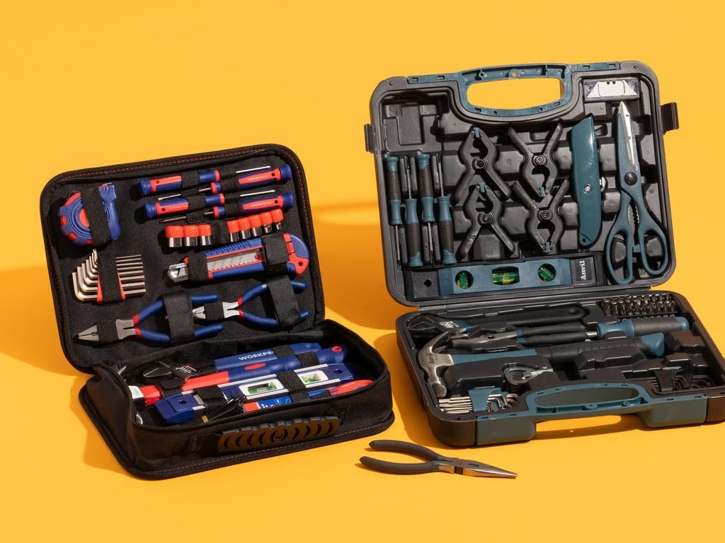 A variety of home appliance repair tools arranged neatly on a wooden workbench in a bright workshop.