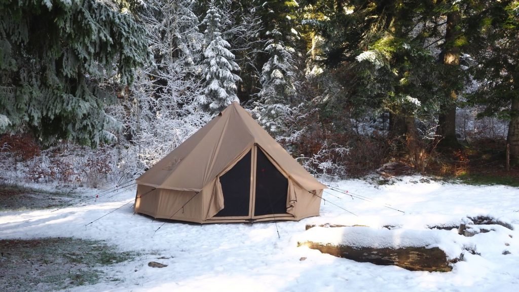 winter tent with stove jack in snowy mountain landscape